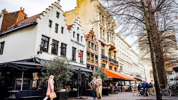 3 vrouwen in warme jas voor gevel van restaurant