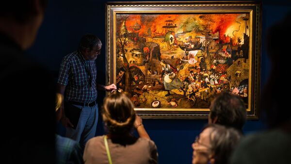 Einige Menschen betrachten in einem Museumsraum das Gemälde „Tolle Grete” von Pieter Bruegel dem Älteren.