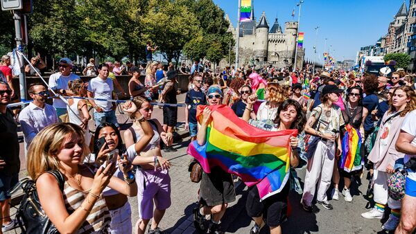 Antwerp Pride: mensen wandelen met regenboogvlaggen. 