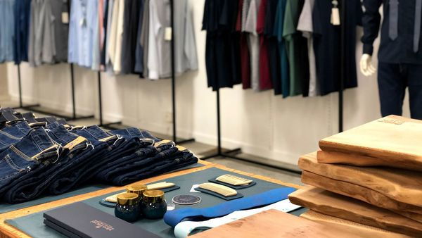 Een winkel voor mannenmode met rekken met T-shirts en hemden