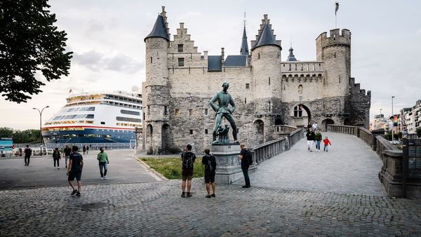 Bezoekers wandelen in en rond de toegangspoort tot het Steen