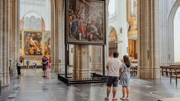 Des visiteurs s'arrêtent devant une œuvre d'art de la cathédrale.