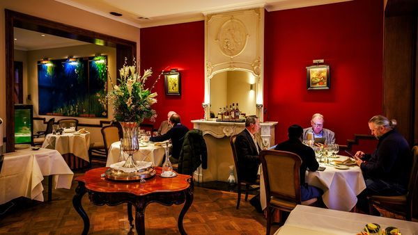 Two tables enjoying good food in the classic and cosy interior of Loncin restaurant