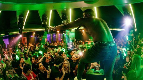 Publiek aan het feesten in een bar met discolichten