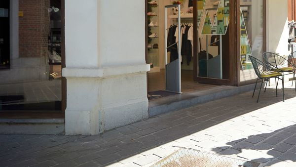 Ein Mann und eine Frau mit Einkaufstaschen gehen eine Einkaufsstraße entlang.