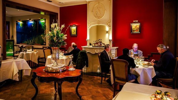 Zwei Tische, die im klassischen und gemütlichen Interieur des Restaurants Loncin ein gutes Essen genießen
