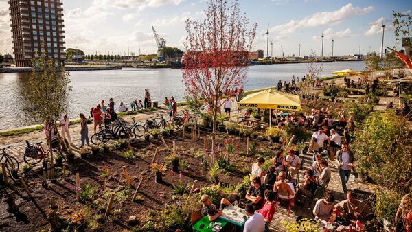 Bar Paniek: people sitting around tables in the background the river Scheldt.
